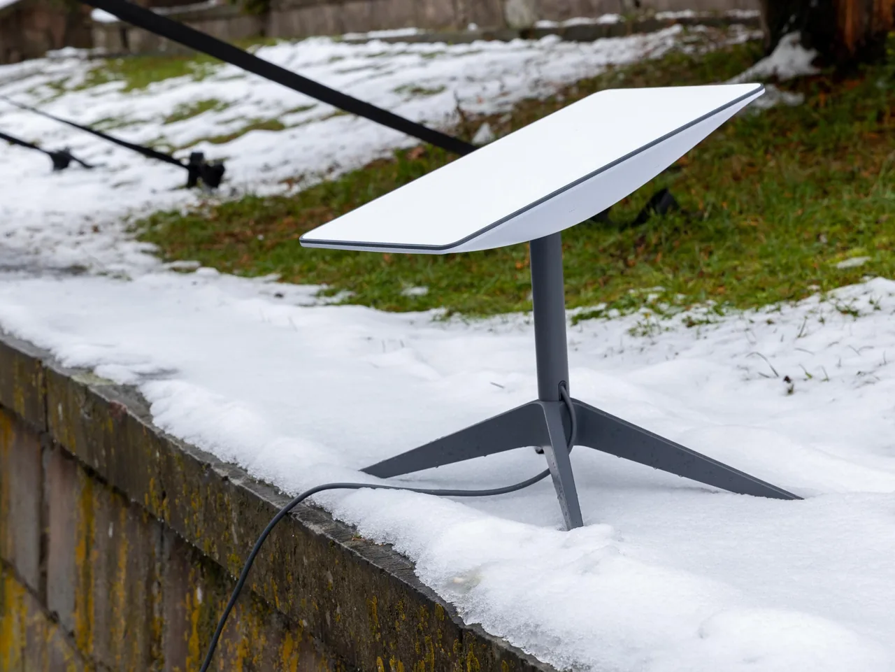 Antena Starlink sobre un soporte en una zona exterior con nieve.
