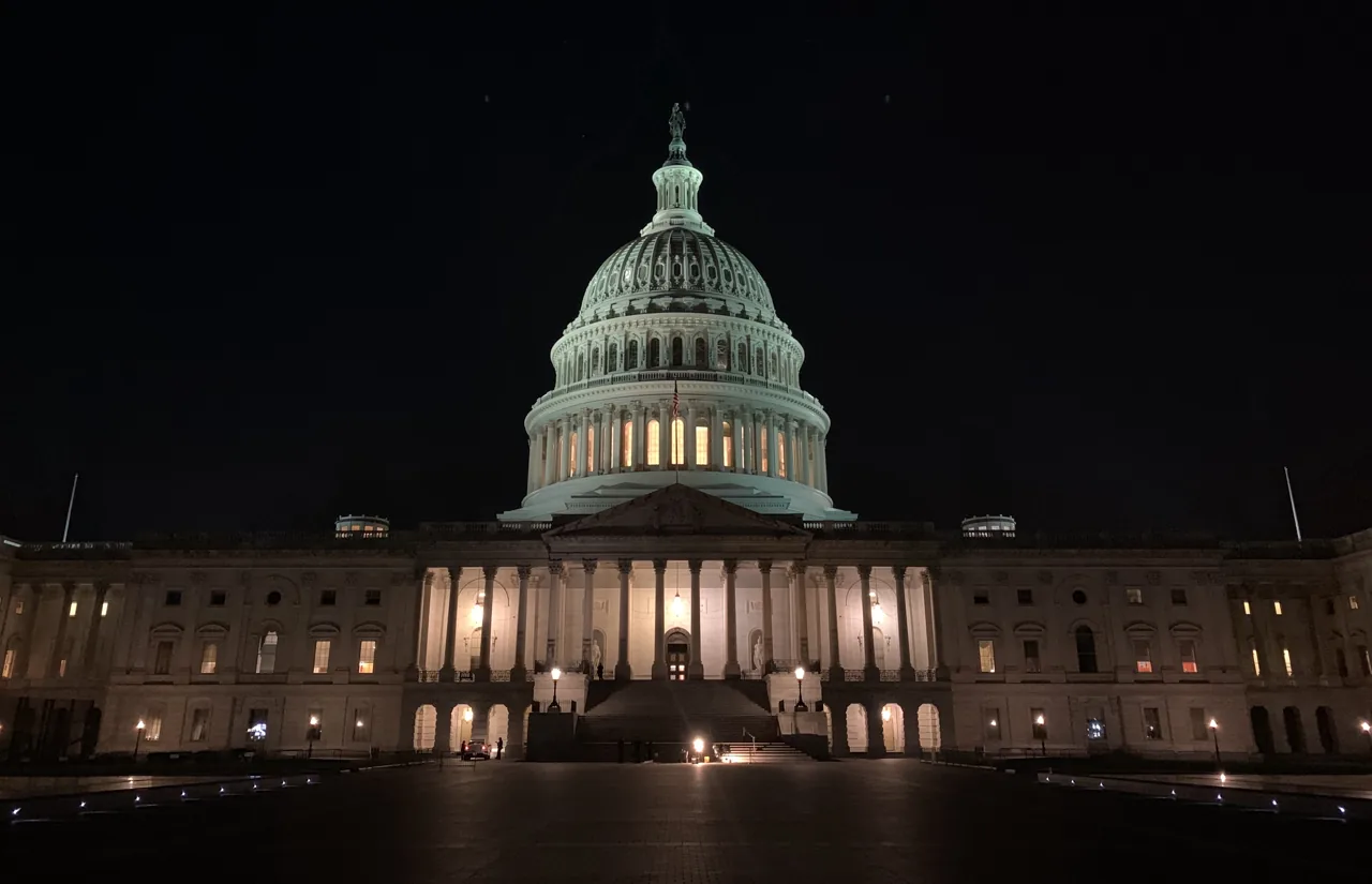 Fachada este y cúpula del Capitolio de Estados Unidos iluminadas de noche.