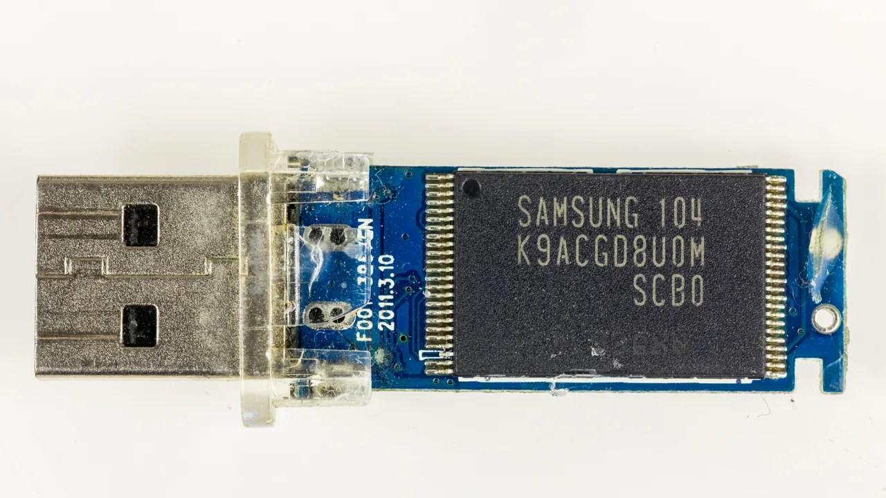 Placa de una memoria USB con su conector y chip de memoria visibles.