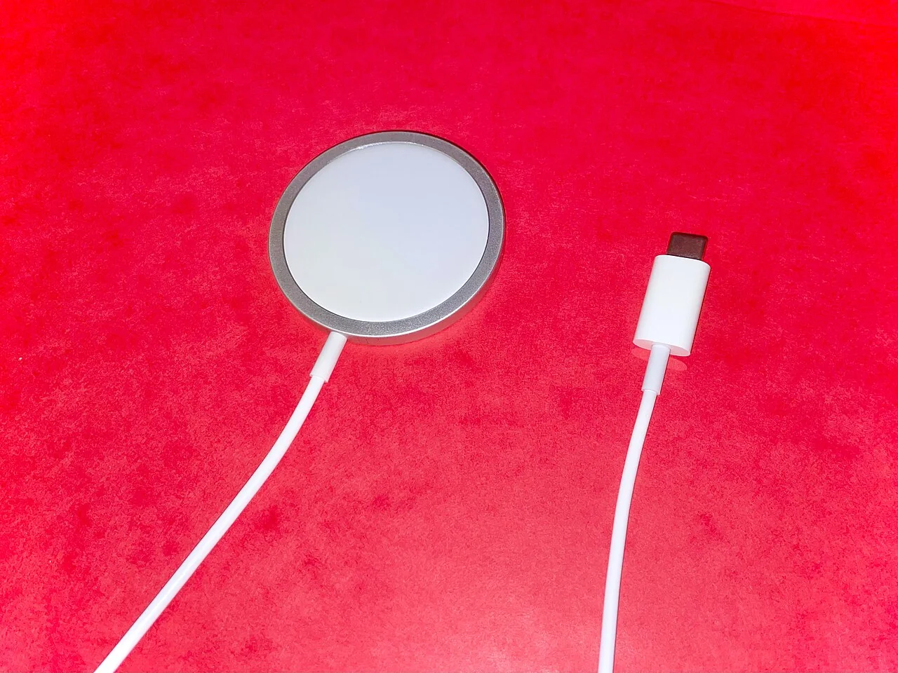 Cargador MagSafe con conexión USB-C sobre una superficie roja