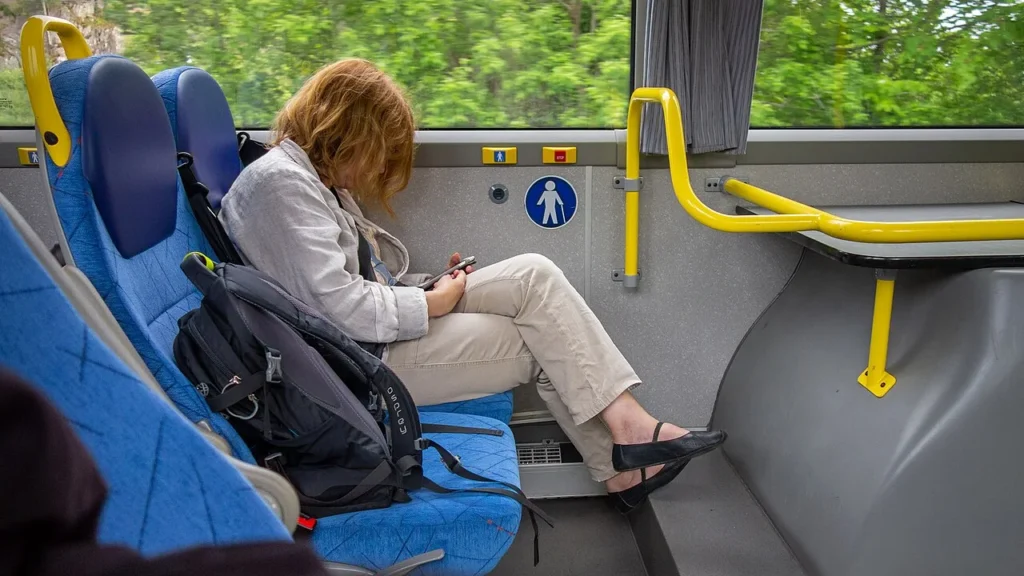 Persona consultando el móvil en un autobús, como contexto sobre la lectura en pantallas pequeñas.