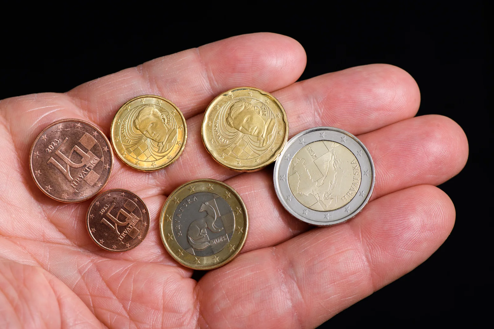 Monedas de euro croatas sobre una mano.