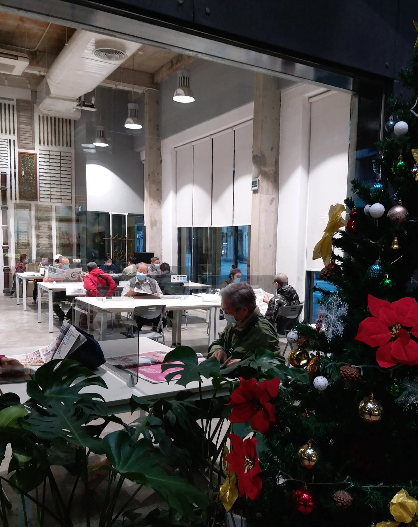 Una persona lee un periódico en una biblioteca.