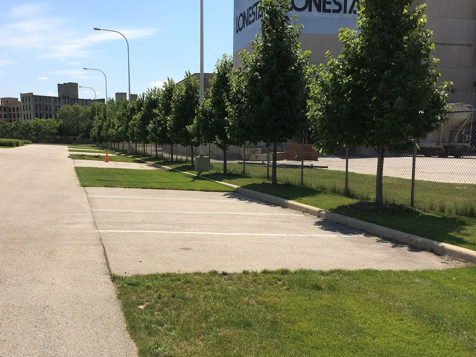 Una zona de aparcamiento con franjas de césped y pavimento.