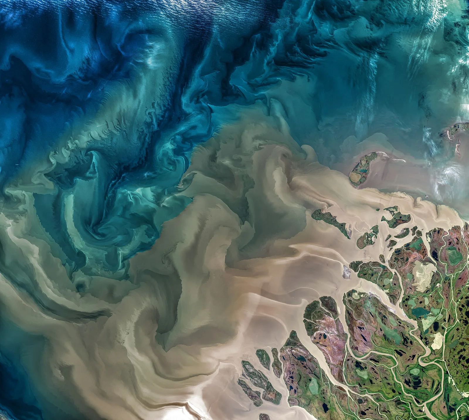 Sedimentos transportados por el río Mackenzie visibles desde un satélite.