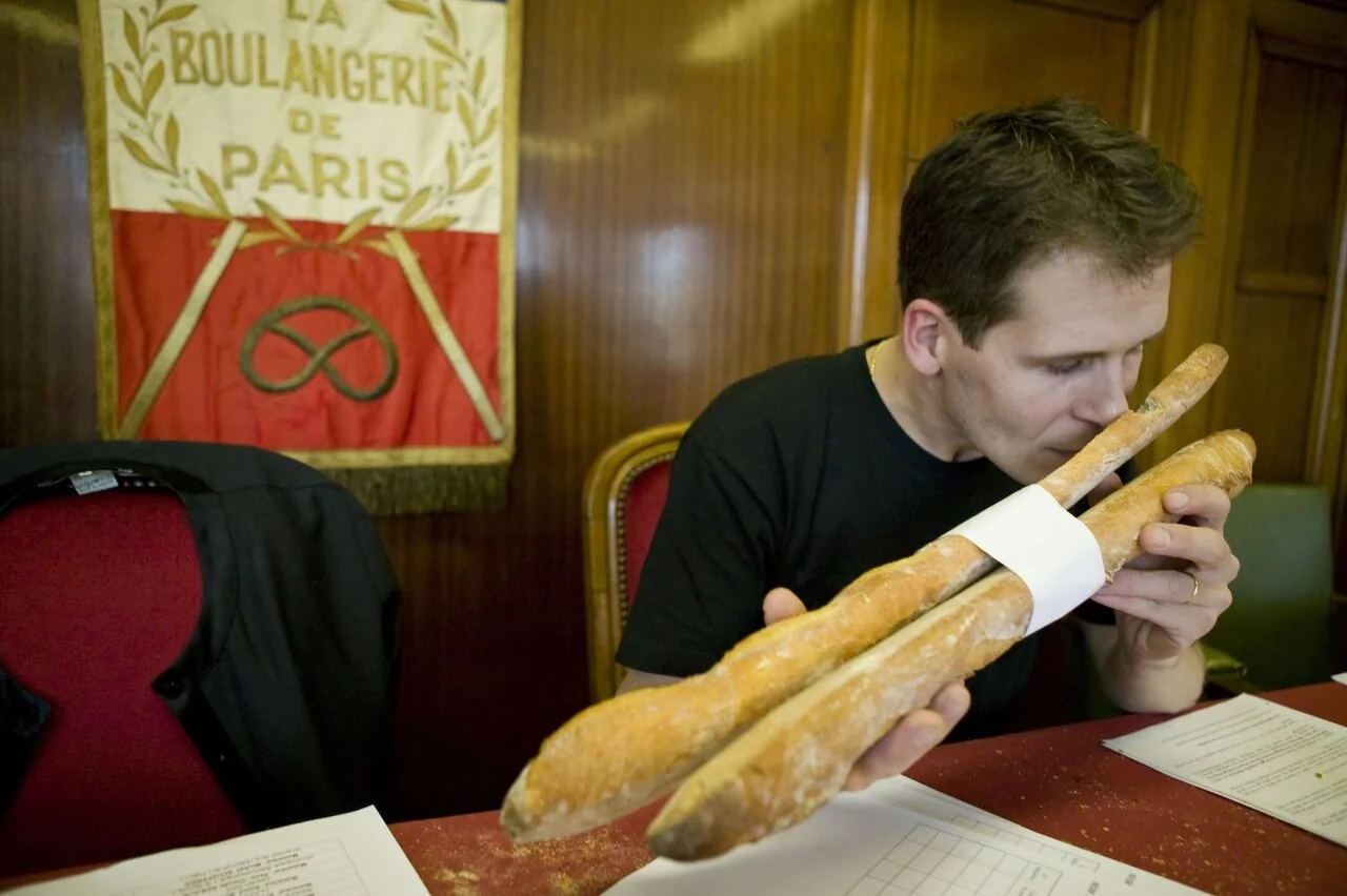 Un miembro del jurado examina una baguette.