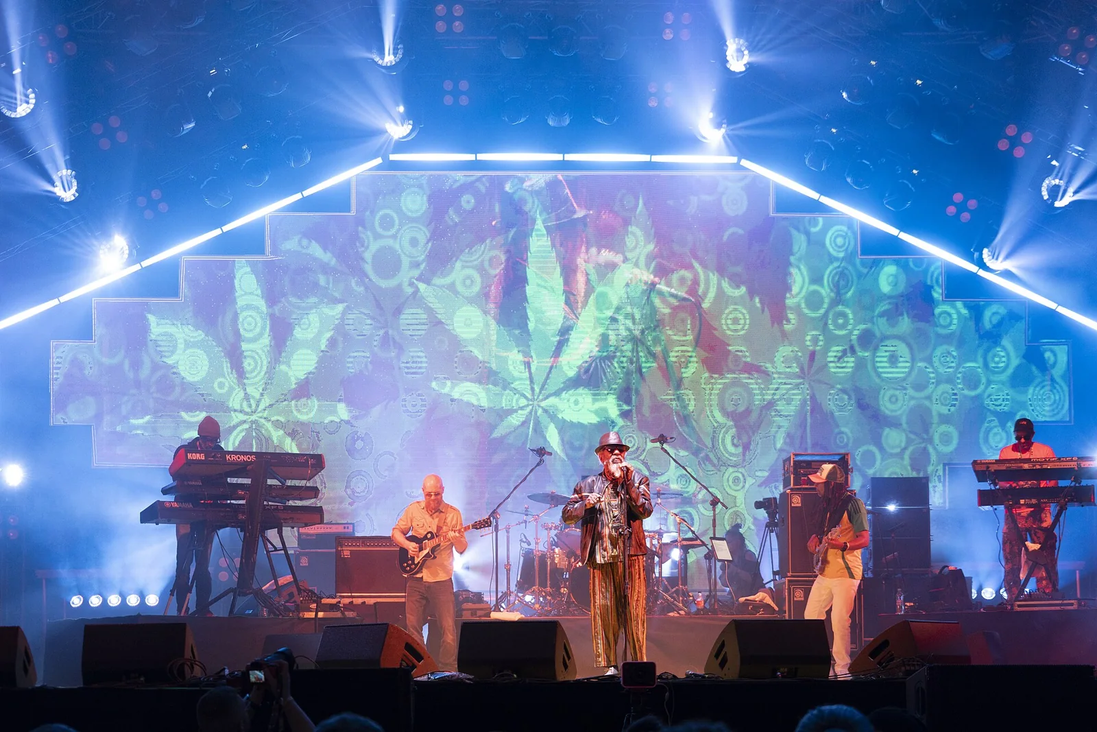 IJahman Levi y músicos en un escenario iluminado.