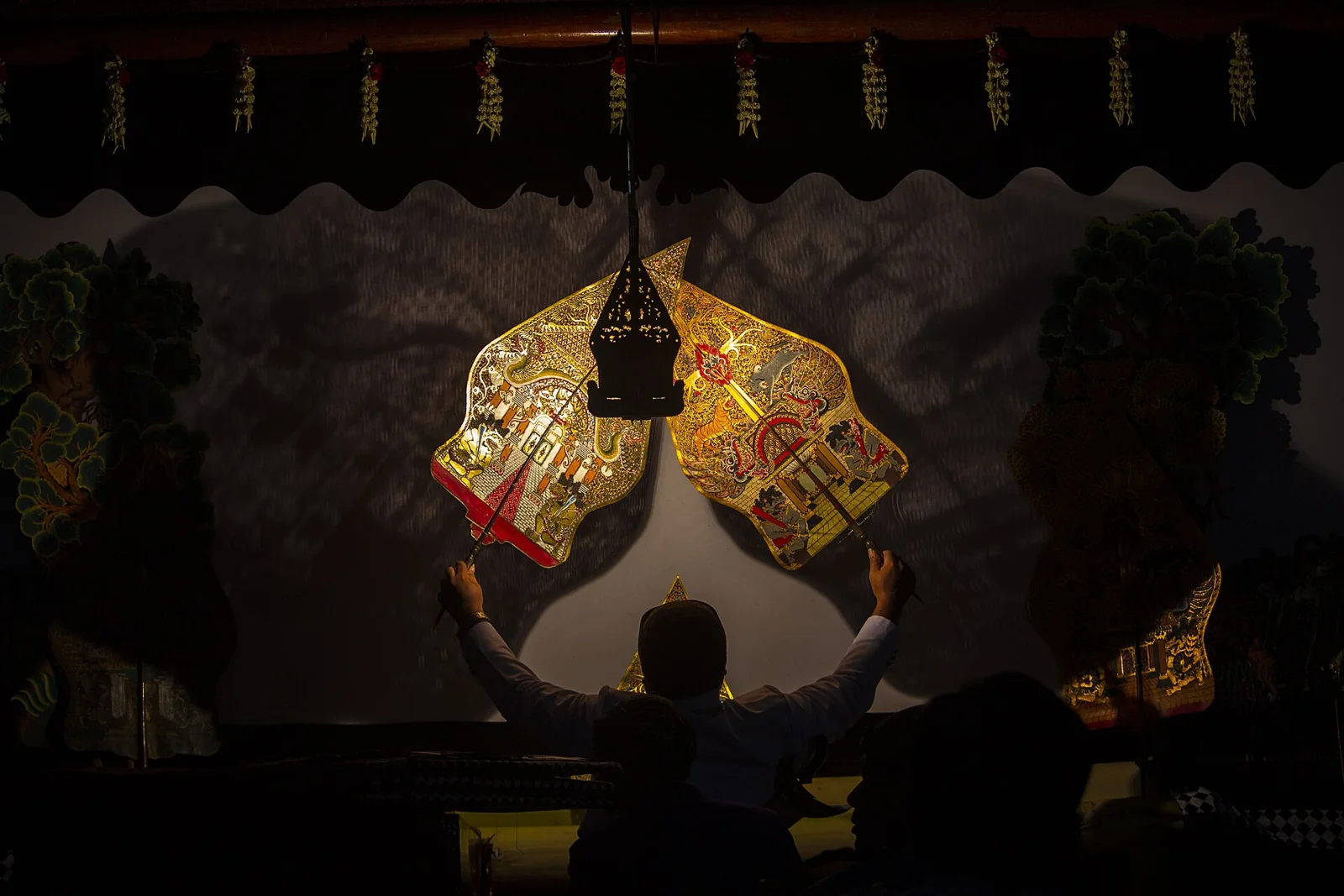Titiritero manejando figuras de wayang kulit.