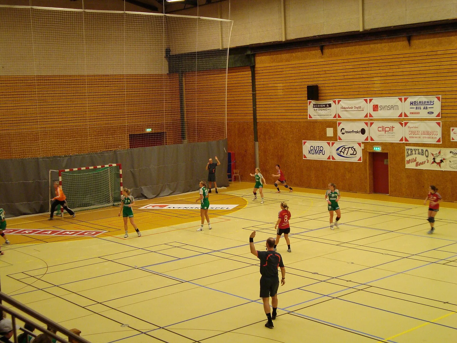 Árbitros y jugadores participan en una acción de balonmano.