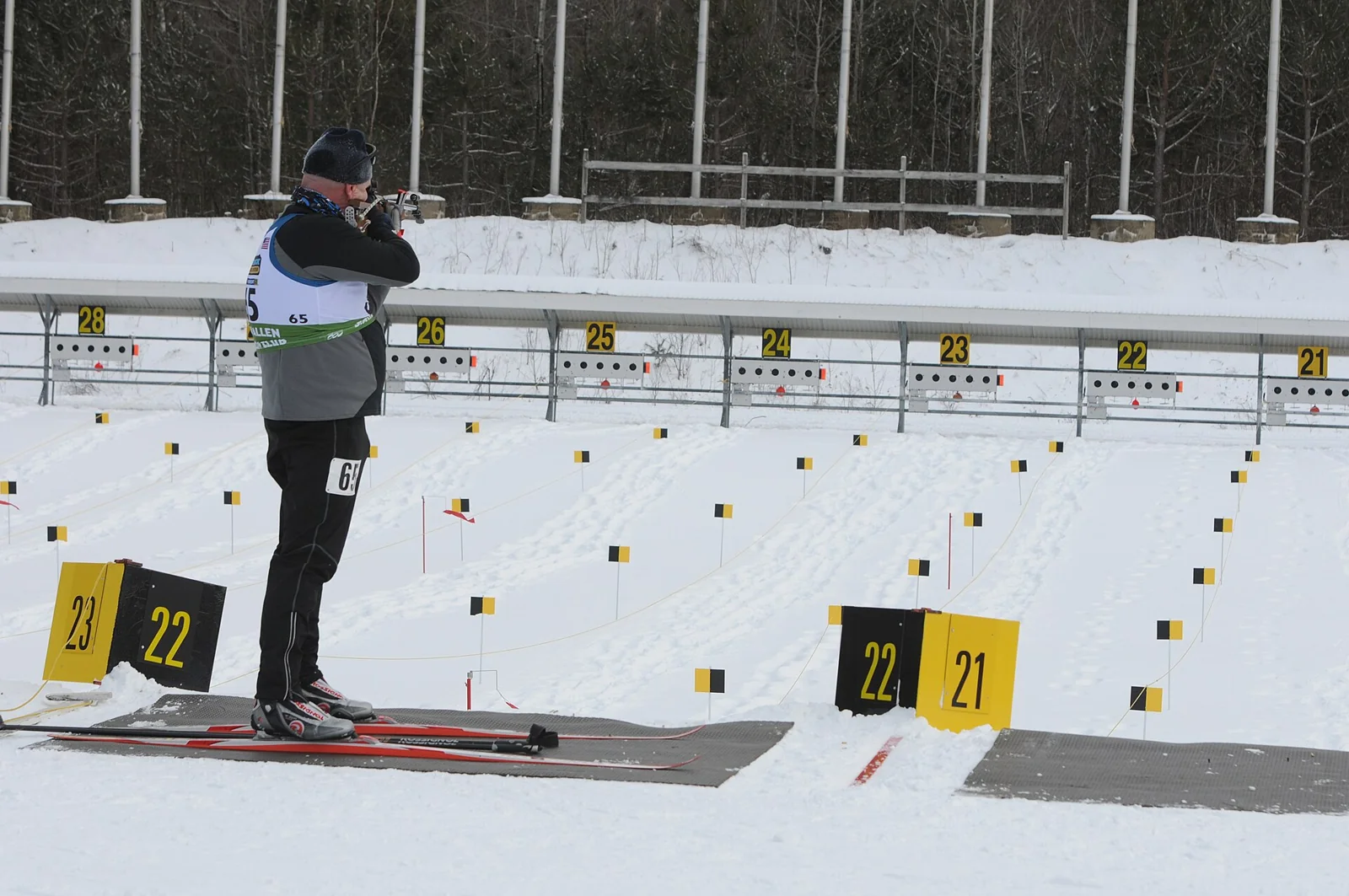 Un participante se prepara para disparar en una competición de biatlón.