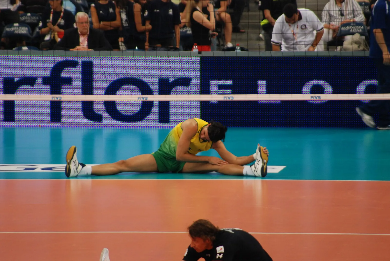 Un jugador de voleibol se estira para alcanzar el balón.