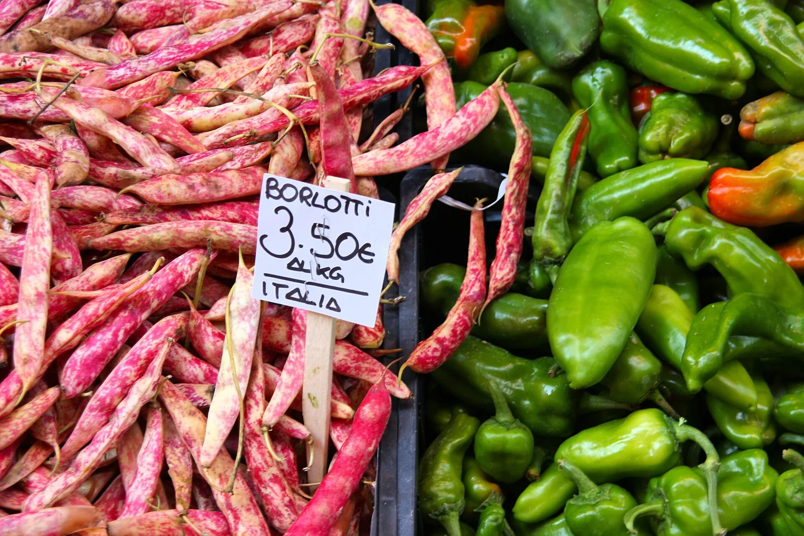 Legumbres y precios expuestos en un mercado italiano.